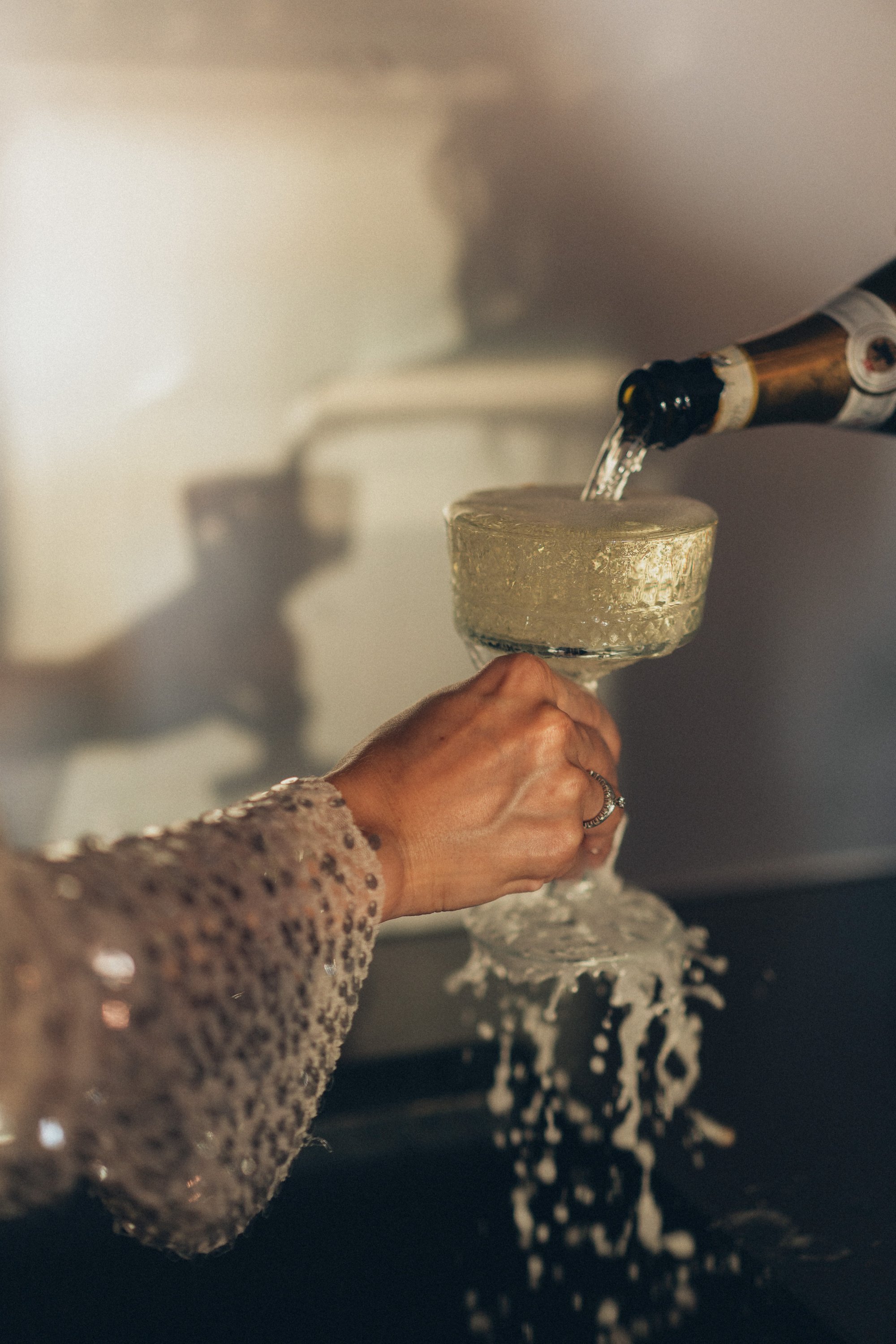 Person Pouring Champagne on Wineglass